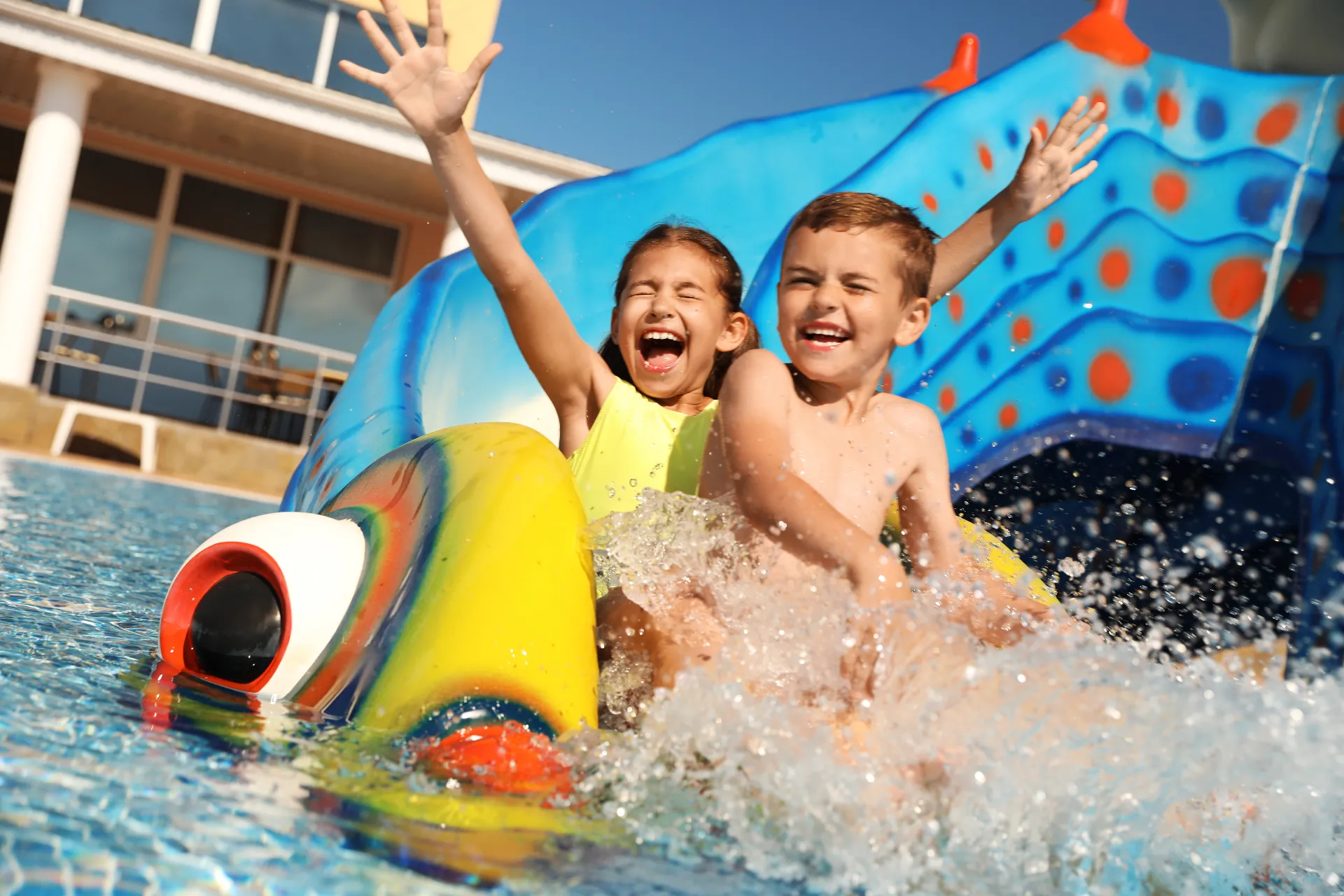 Zwei Kinder auf einer bunten Wasserrutsche