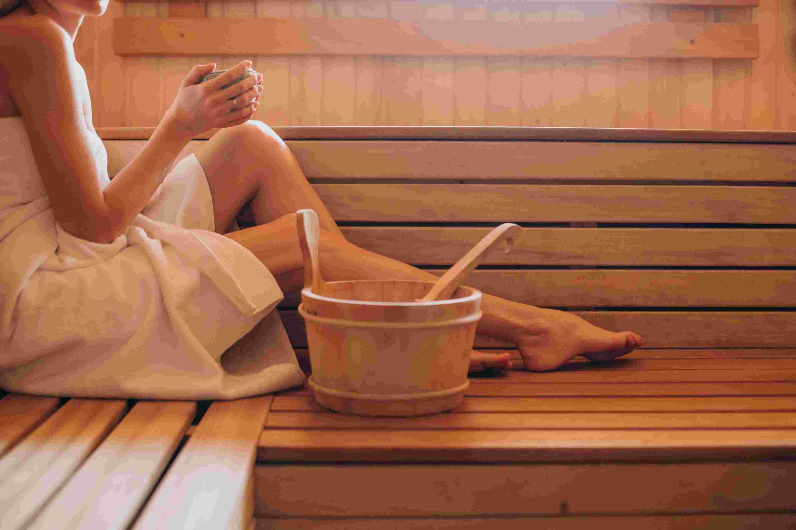 Frau in einer Sauna mit Aufguss Bottich